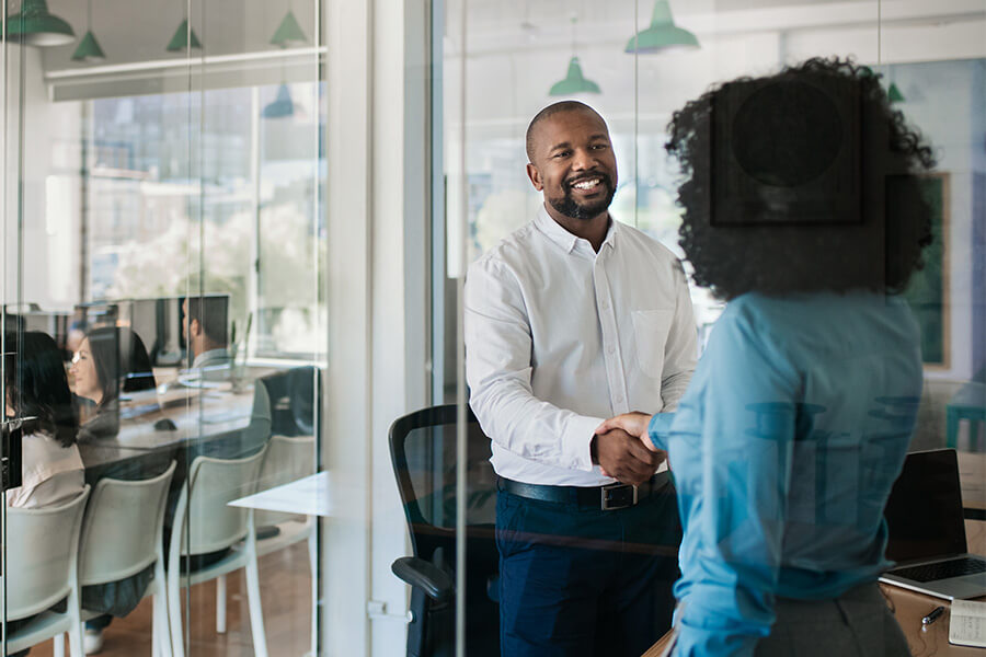 Man and woman in an office shaking hands