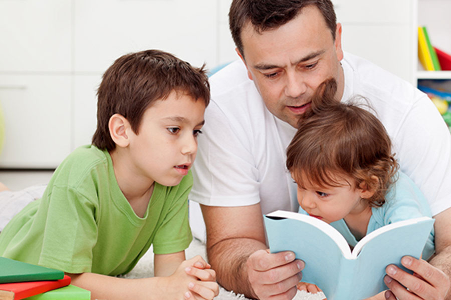 Father reading to to son and daughter