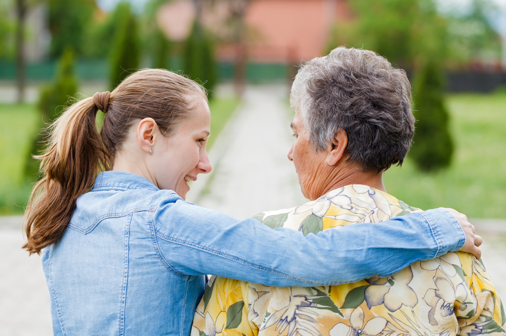 A woman embraces an older woman